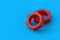 Red metal nuts on blue background. Construction materials. Industrial equipment