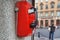 Red metal phone, automatic, payphone hangs on the wall on St. Petersburg city street in Russia