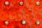 Red metal plate painted with strong red and orange colours and fixed with six large steel bolt screws as texture background