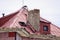 Red metal roof with broken chimney and open dormer