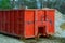 Red metal waste container with building debris