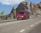 Red minibus moves on a road in the mountains