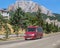 Red minibus moves on a road in the mountains