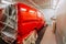 Red minivan in paint booth. Car workshop details, painting of a car