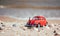 Red model of a retro car on a background of a sandy beach in Los Angeles, California, USA