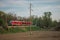 Red modern commuter passenger train in a rural environment. Slovenian german made passenger train on a cloudy day