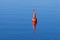 Red modern navigation buoy on still water