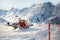 Red modern snowcat ratrack with snowplow snow grooming machine preparing ski slope piste hill at alpine skiing winter resort