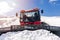 Red modern snowcat ratrack with snowplow,snow grooming machine,remover truck preparing ski slope,piste,hill at alpine