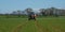 Red modern tractor pulling a crop sprayer