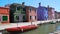 Red motorboat parked on Venetian canal, view on beautiful colorful houses