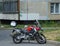 A red motorcycle is parked in the courtyard of a residential building