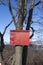 Red mountain guidepost on a tree