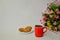 Red mug of black coffee, oatmeal cookies with cereals and a bouquet of Alstroemeria on a white background.