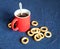 Red mug of black tea and dryings are on the table close-up