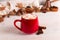 Red mug with cocoa and marshmallows, on a background of a scarf and dry leaves. Autumn mood, a warming drink