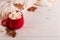 Red mug with cocoa and marshmallows, on a background of a scarf and dry leaves. Autumn mood, a warming drink