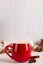 Red mug with cocoa and marshmallows, on a background of a scarf and dry leaves. Autumn mood, a warming drink