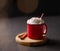 Red mug with hot chocolate or cocoa with whipped cream on a wooden stand with cinnamon sticks on a dark background