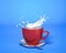 Red mug with milk splash. On blue background