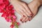 Red nail art with printed flowers on wooden background