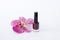 Red nail polishes stand near beautiful pink flower