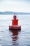 Red navigation buoy floating on sea water