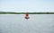 Red navigation buoy on still sea water