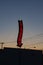 A red neon liquors store sign glowing during a sunset