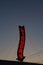 A red neon liquors store sign glowing during a sunset