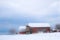 Red New England barn in winter with snow