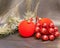 Red New Year\'s ball, decorative berries and tinsel
