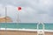 Red no swimming flag and lifeguard hut