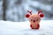 a red-nose reindeer toy on a snowy surface