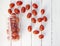 Red oblong cherry tomatoes, on a white background of boards. Top view