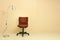 Red office chair with lamp over light beige wall background.