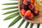 Red Oil Palm seed in a basket and leaf with cooking palm oil in glass on white background