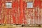 Red old barn windows and lonely bench