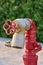 Red old fireplug with white valve against of a wall background