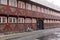 Red old house with white windows - half-timbered house made of wood and bricks. Bicycle near the wall