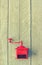 Red old mechanical coffee grinder on white wooden table.