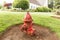Red old shabby fire hydrant on a lawn