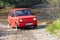 Red oldtimer car Fiat 126 overcomes water obstacle