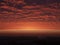 Red ominous clouds hovering above the ground at dawn. Red-tinted sky at sunrise. Landscape of tonal reds