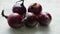 Red onion bulbs on white table