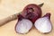 Red onions cutting with a knife on a wooden board