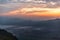 Red, oragne and blue dynamic sunrise with fog laying in valley