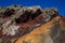 Red, orange and black stratified cliffs in Santorini