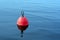 Red-orange buoy in the blue water