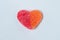 Red and orange gummy heart on a light blue background